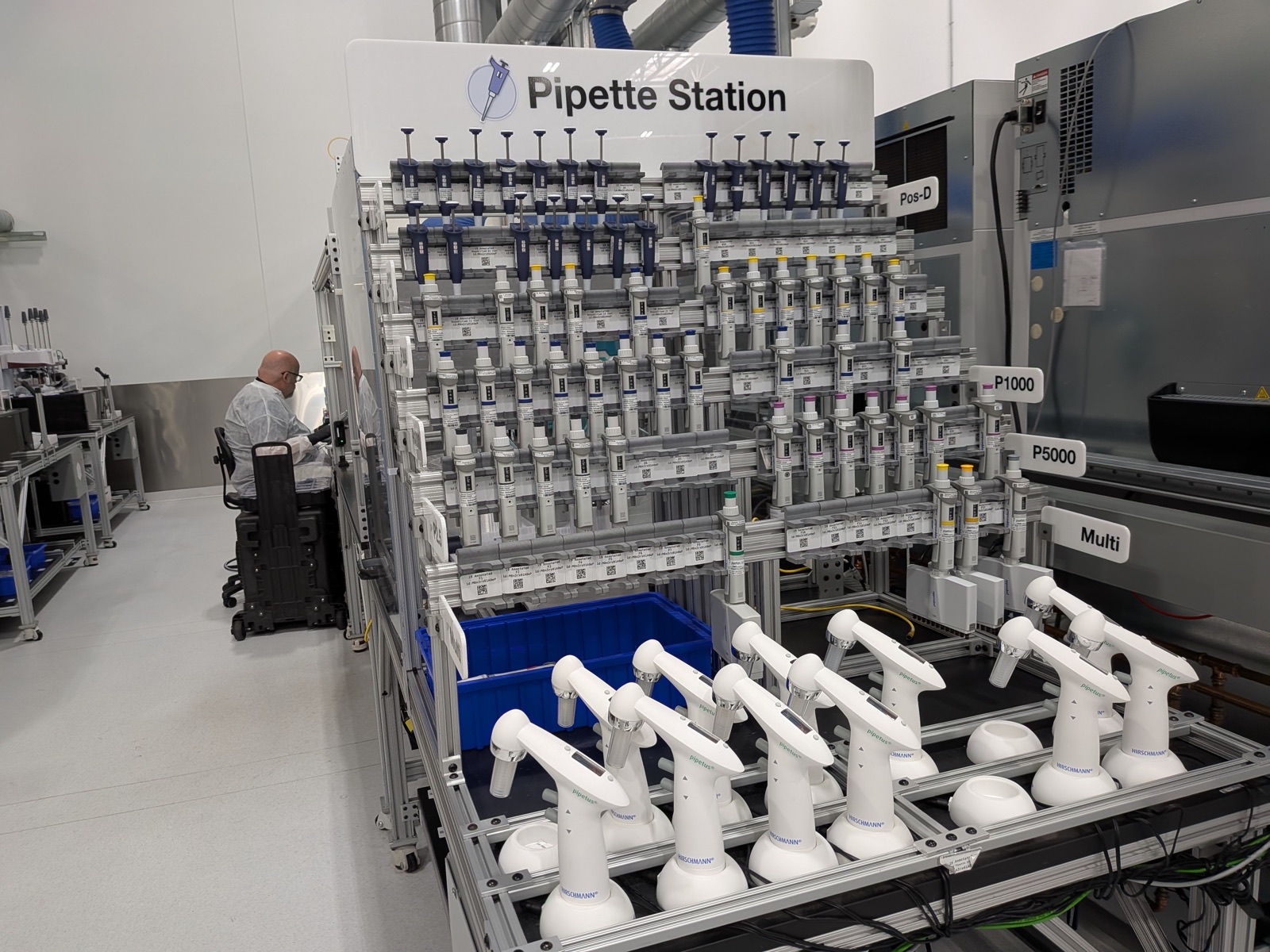 A rack labeled 'Pipette Station' holding dozens of pipettes, each tagged with its own QR-code label.